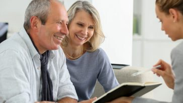 smiling older couple speaking with financial planner
