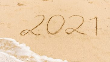 sandy beach with 2021 scrawled in sand