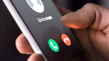 hand holding smartphone displaying unknown number call
