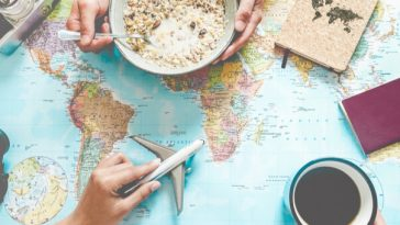 couple looking at world map over breakfast with cereal and coffee