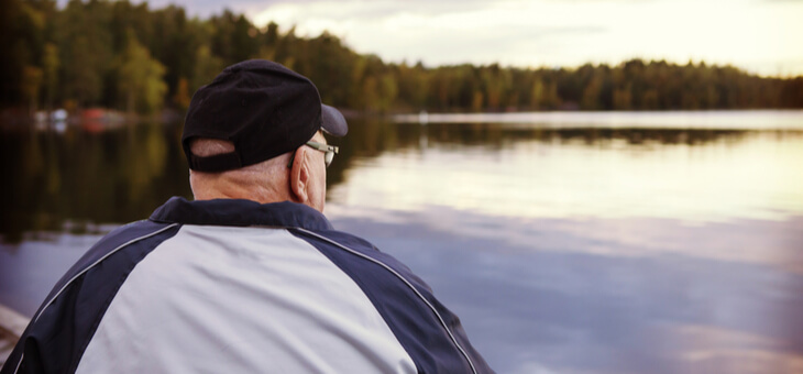 rear view of older man staring out over lake