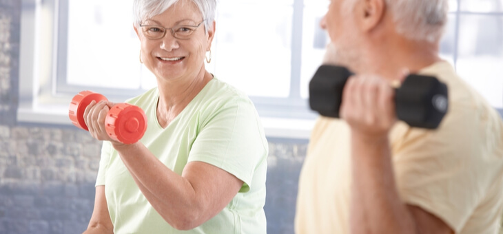 older couple lifting small weights
