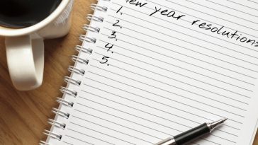 pen resting on notepad that reads new years resolution on top line