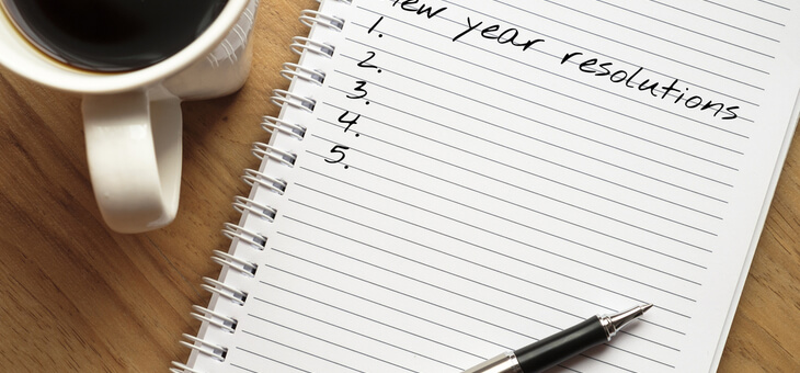 pen resting on notepad that reads new years resolution on top line