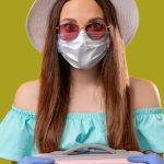 woman dressed for summer holiday wearing face mask