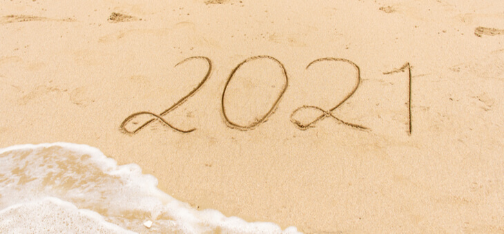 sandy beach with 2021 scrawled in sand