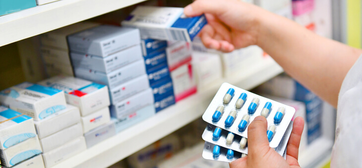 pharmacist stacking medicines on shelf