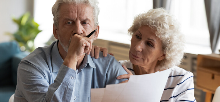 older couple with bills looking worried