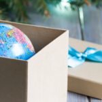 toy globe in box under christmas tree