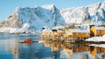 snowy mountains surrounding bay in norway