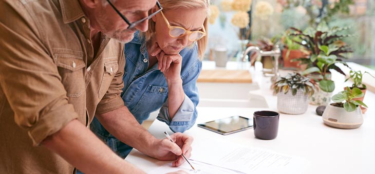 Mature Couple Reviewing And Signing Domestic Finances