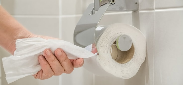 hand pulling toilet paper from roll