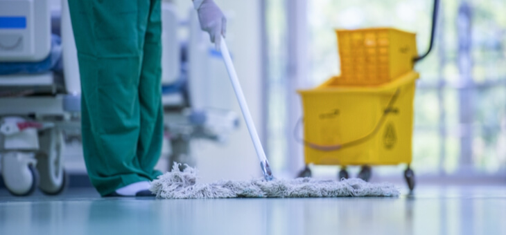 cleaner mopping floor of hospital ward