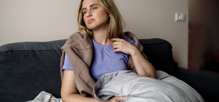 woman lying in bed looking ill