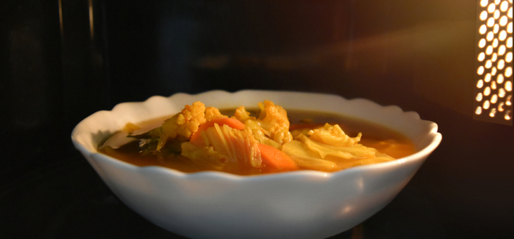 bowl of vegetables cooking in microwave