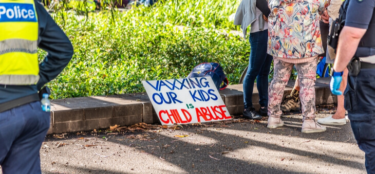sign at anti vax rally that reads vaxxing our kids is child abuse