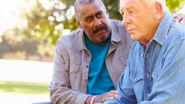 two older men speaking on park bench