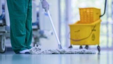 cleaner mopping floor of hospital ward
