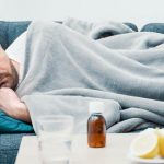 man lying on his couch sick with covid