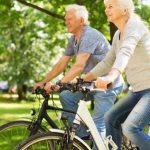 older couple riding bicycles in the park