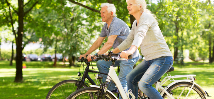 older couple riding bicycles in the park