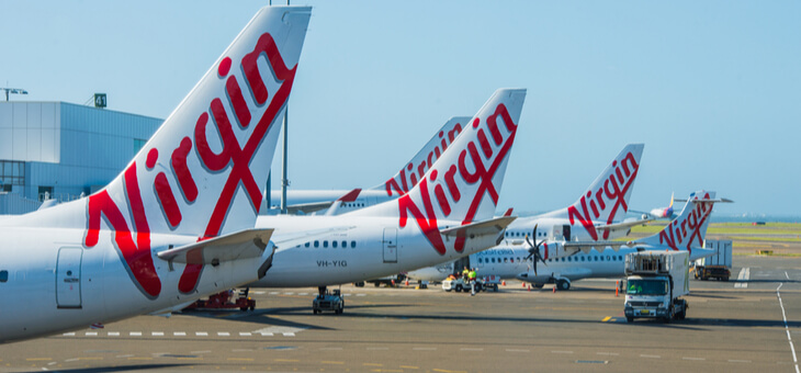 tails of three virgin planes sitting on tarmac