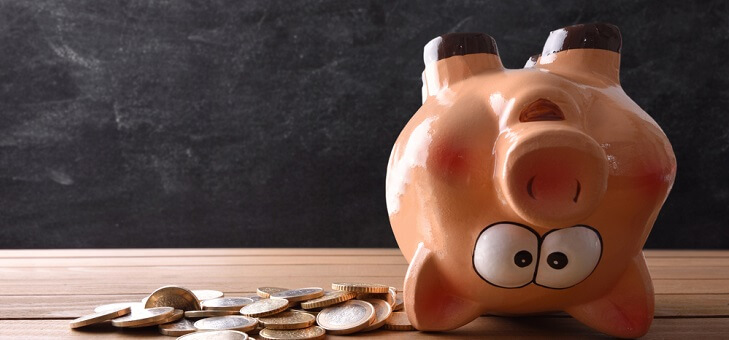 upside down piggy bank surrounded by coins