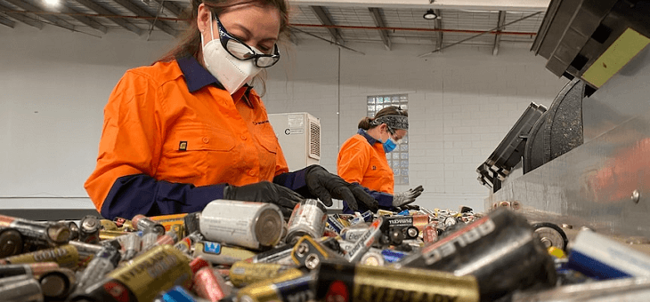 woman sorting batteries in recycling facility