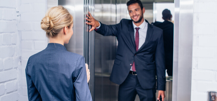 man holding elevator for woman