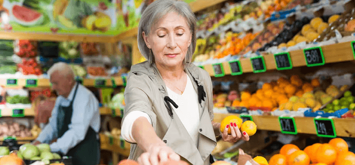 woman choosing lemons in fruit shop