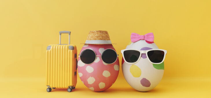 two easter eggs wearing sunglasses with a packed suitcase