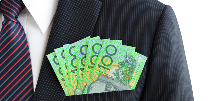 man wearing suit with stack of hundred dollar notes in top pocket