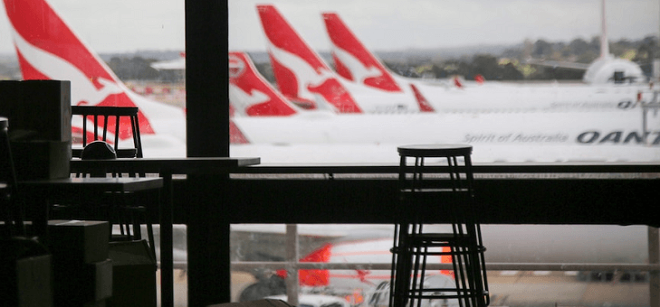 view of three qantas planes waiting at gates