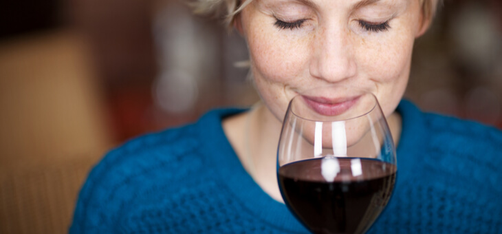 woman about to sip glass of red wine