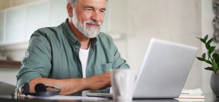 mature man working from home in kitchen