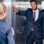 man holding elevator for woman