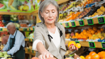 woman choosing lemons in fruit shop