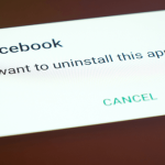 hand holding phone displaying facebook delete notification
