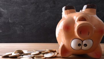 upside down piggy bank surrounded by coins