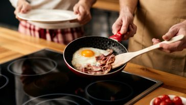 person cooking bacon and eggs