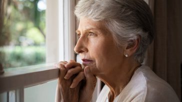 older woman staring out window