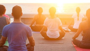 people meditating at sunrise on a retreat