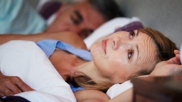 woman lying awake in bed at night