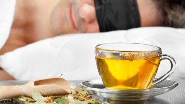 cup of herbal tea on bedside table next to sleeping man