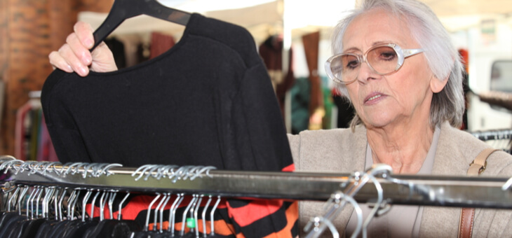 elderly woman scowling at price of blouse pulled off the rack