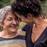 older woman laughing with adult daughter