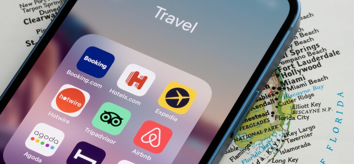 iphone screen with airbnb logo on top of usa map