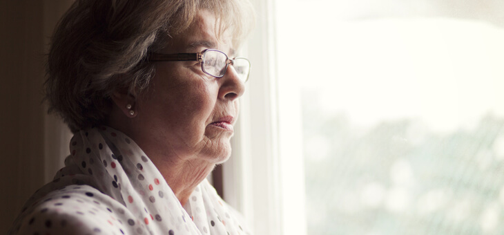 sad older woman staring out window