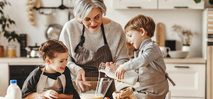 grandmother baking in kitchen with grandchildren
