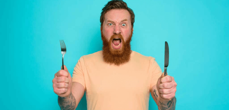 Hungry man with knife and fork